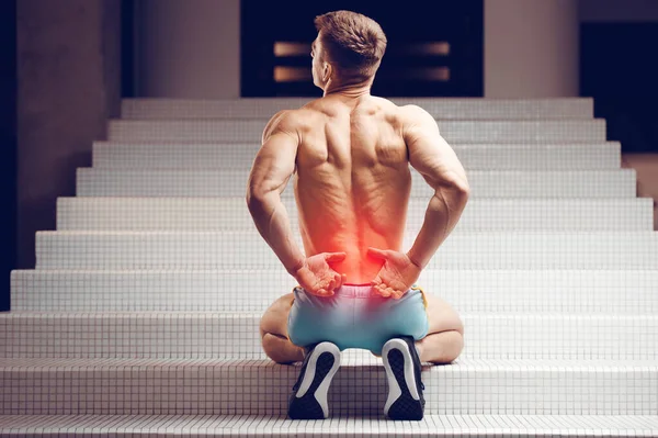 Verletzung Der Wirbelsäule Junge Gut Aussehende Muskulöse Athletin Mit Rückenschmerzen lizenzfreie Stockfotos