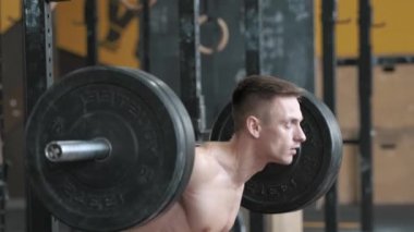 Spor salonunda halterle çömelmiş kaslı bir sporcu. Spor, ağırlık kaldırma ve sağlık hizmetleri kavramı