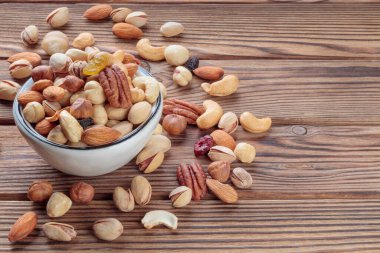 Mixed nuts on wooden background. Walnut, pistachios, almonds, hazelnuts and cashews. Selective focus