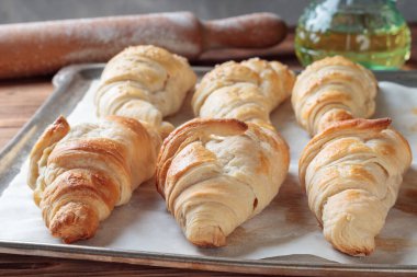 Close-up view of homemade croissants on a baking paper. Selective focus.