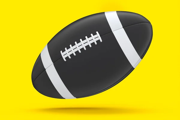 Nero palla da calcio americano isolato su sfondo giallo — Foto Stock