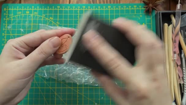 Frauenhände polieren Tonfiguren mit Schleifpapier. — Stockvideo