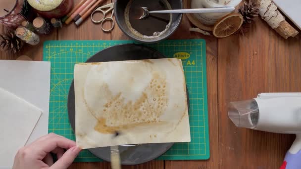 Artistas mãos decorar papel artesanal em prato com água e café. — Vídeo de Stock