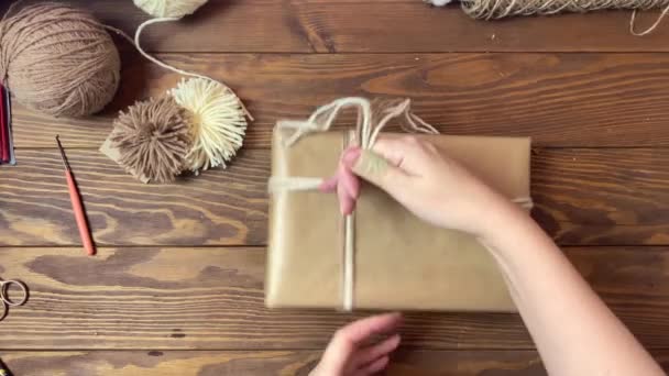 Mulheres mãos laços caixa de presente em papel artesanal com fio. — Vídeo de Stock