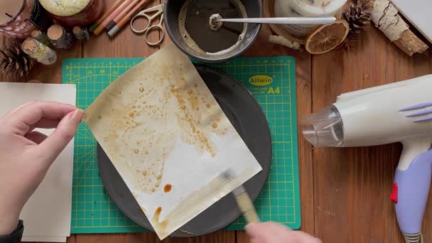 Kunstenaar versieren papier met water en koffie en drogen met haardroger. — Stockvideo