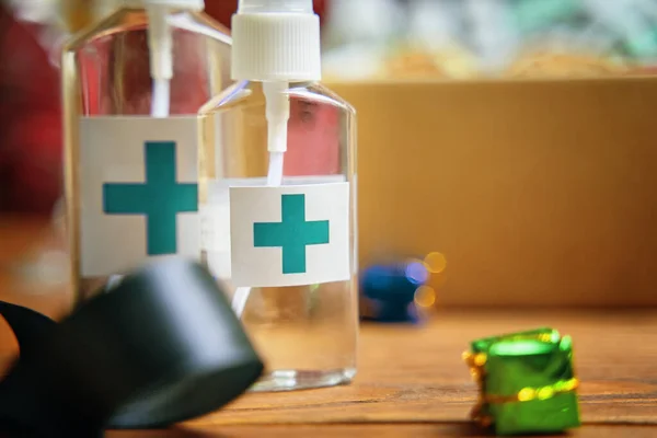 Twee ontsmettingsmiddelen met turquoise kruis logo op houten tafel. — Stockfoto