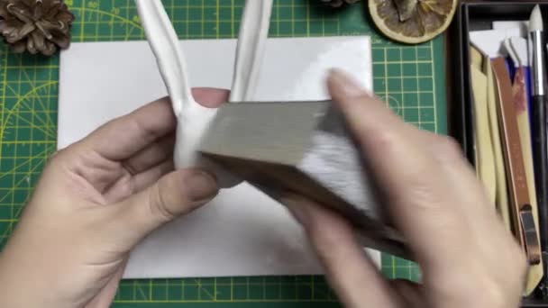 Dámské ruce leštit hliněné figurky s brusným papírem. — Stock video