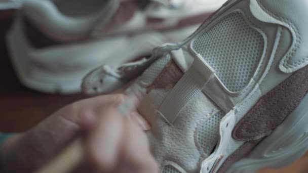 女性的手与刷漆白色运动鞋与棕色丙烯酸. — 图库视频影像