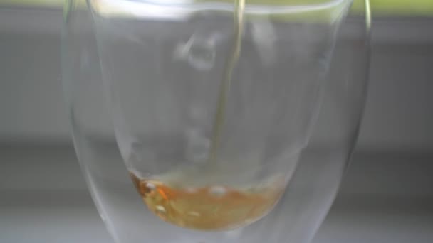 Copa transparente de vidrio está lleno de té aromático caliente. — Vídeo de stock