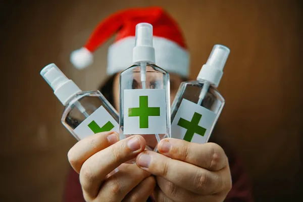Alcohol antiseptics with red cross on label in hands. — Stock Photo, Image