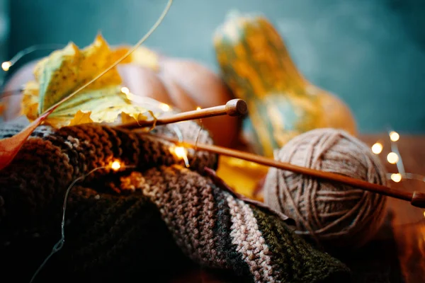 Autumn composition with yarn, wooden needles, lights and pumpkins. — Stock Photo, Image