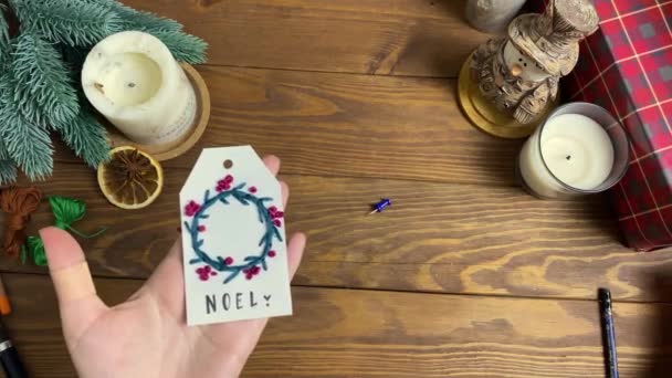 Les mains féminines placent une étiquette sur une table en bois et prennent une boîte cadeau. — Video