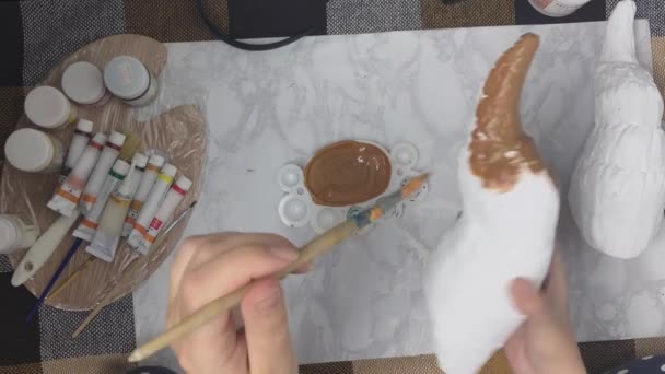 Mãos de mulheres pintam chifre branco com tinta marrom. — Vídeo de Stock