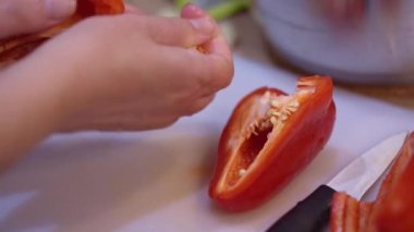 Kadınların elleri kırmızı dolma biberi temizler..