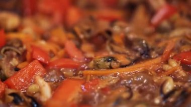 Deniz ürünleri ve sebzeler kızgın soslu tavada pişirilir..