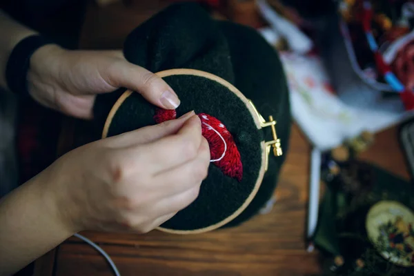 Womens hands embroiders fly agaric hat on frame. — Stock Photo, Image