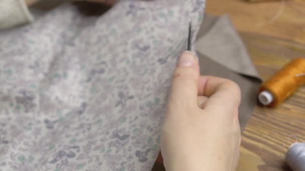 Womens hands cut piece of floral fabric with sewing scissors. — Stock Video