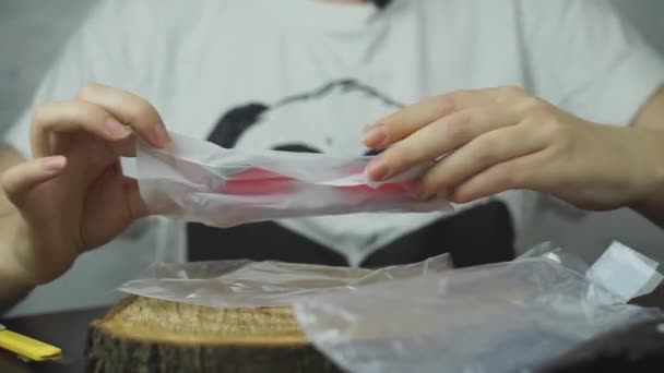 Womens hands take out colored glasses from plastic wrap. — Stockvideo