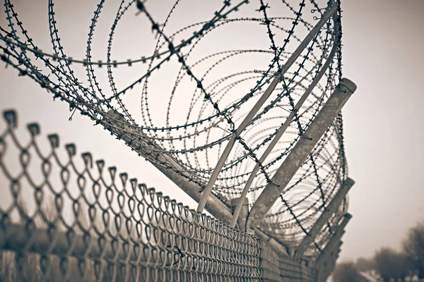 监狱栅栏。铁丝网带刺铁丝网. 图库图片