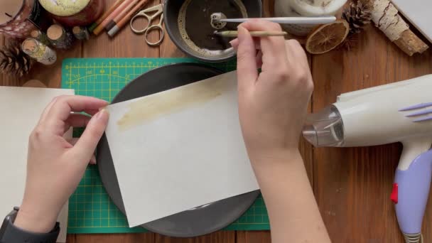 Художник украшает белую бумагу в блюде водой и кофе. — стоковое видео