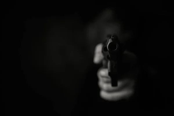 Muzzle of gun in mans hand är riktad mot kameran. — Stockfoto