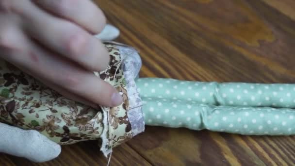Women sews a cute cloth doll. — Stock Video