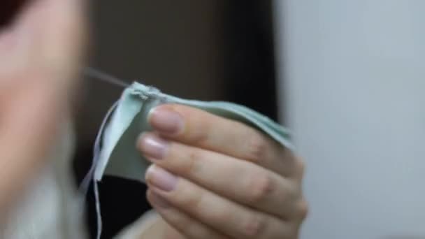 Girl sews piece of fabric with threads. — Stock Video