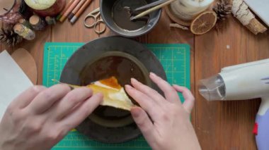 Kadın eli yakın plan kahve tabağına kağıt batıran bir fotoğraf. Saç kurutma makinesi, ahşap masada ofis malzemeleri. Hatıra defteri tasarımı ve yaşlanması.