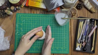 Kadın beyaz çamurdan yumurta kalıbı yapıyor..