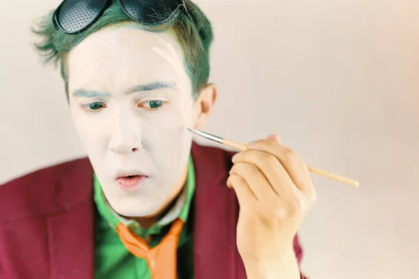 Cosplayer ragazzo dipinge il suo viso con pennello. — Foto Stock