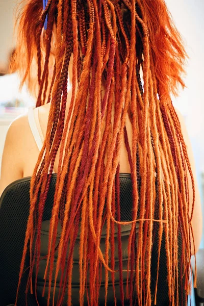 Blick von hinten auf Mädchen mit roten und orangefarbenen Dreadlocks aus dem Kanekalon. — Stockfoto