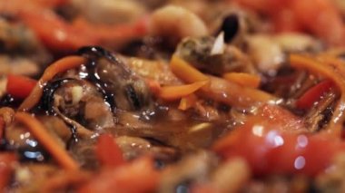 Sos, deniz ürünleri ve sebzelerle kızartma tavasına dökülür..