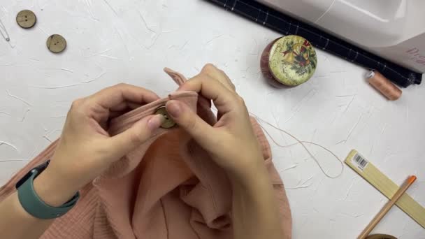 Les mains des femmes créent des vêtements en mousseline de coton. — Video