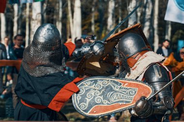 Gri giyen şövalye, kalkanında kurt olan bir şövalyeye karşı..