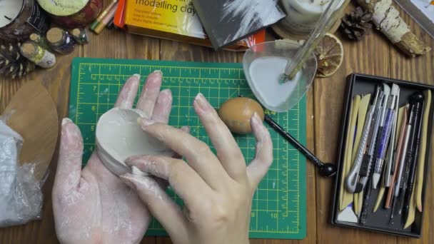 Meister mit feuchten Händen macht Eierform aus weißer Tonerde. — Stockvideo