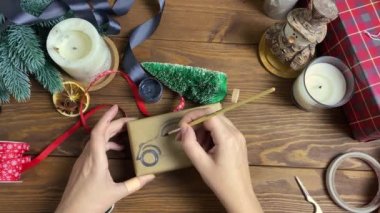 Womens hands draw car with brush and paint on gift box.