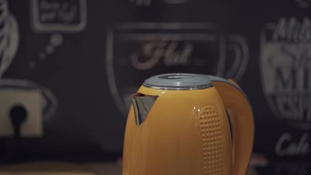 Mans hand opent en sluit het deksel van een oranje waterkoker. — Stockvideo