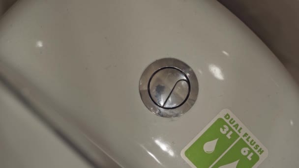 人間の指の上のビューは、トイレのフラッシュボタンを押す. — ストック動画