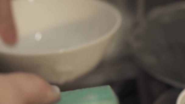 Close-up of male hands with a sponge washing dishes in the sink. — Stock Video