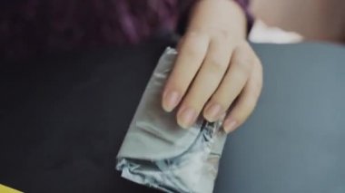 Siyah bir masanın üzerinde ipek kumaş bir uyku maskesi paketi açıyor. İnternetten alışveriş. Bir gecelik istirahat için suç ortağı.