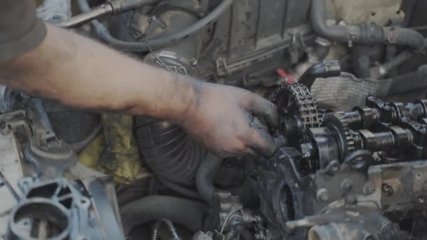 修理後 エンジンカムシャフトチェーンのプーリーにボルトを締め裸と汚れた手を持つ機械 — ストック動画