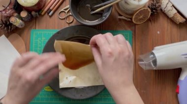 Kadın eli yakın plan kahve tabağına kağıt batıran bir fotoğraf. Saç kurutma makinesi, kalemler ve tahta masadaki diğer nesneler. Albüm albümü için tasarım ve dekorasyon kağıdı.