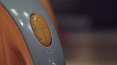 Elektrikli su ısıtıcısının düğmesine basan birinin yakın çekimi. Ev aletleri mutfak masasında. Sabah sıcak içecekleri yapmak için ev yemekleri.