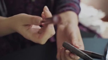 Three eyebrow markers in womens hands. Female holds and demonstrates a cosmetic product for make-up. Blogger runs a channel about fashion and glamour.
