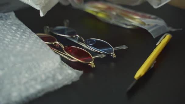 Unpacking Colored Eyewear Black Table Persons Gloved Hands Touching Sunglasses — Stockvideo