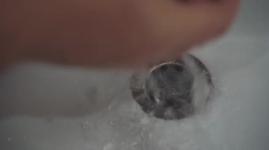 Person opens the water tap and washing hands. Hygiene procedures. Powerful jet of water pours into the bathroom sink.