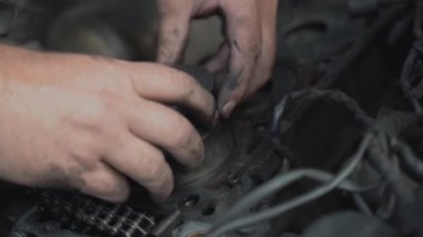 Workshop worker installs pistons with new rings close up
