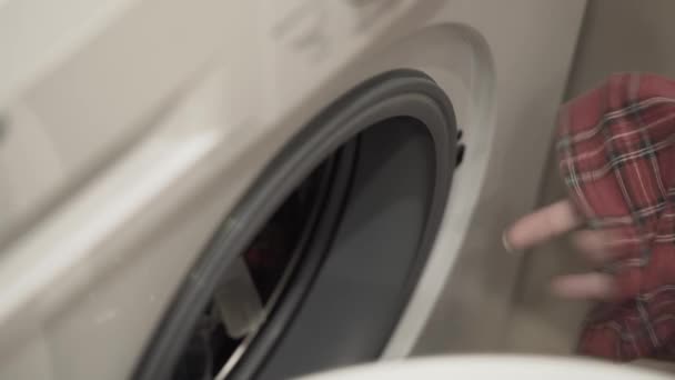 人们准备脏衣服在洗衣机里洗 女人的手把衣服叠进洗衣机的鼓里 关上了门 卫生和清洁 家务活 — 图库视频影像