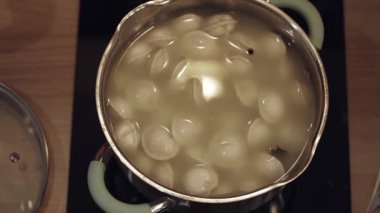 Su ve baharatlı soslu hamur tatlısı. Cam seramik mutfak sobasında akşam yemeği için nefis bir yemek. Misafirler ya da aileler için lezzetli bir öğle yemeği hazırlıyorum..