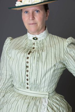 Viktorya döneminden kalma bir kadın tenis kıyafeti giyiyor.